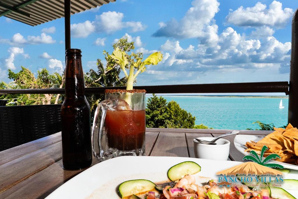 a table with a plate of food and a drink at Hotel Pancho Villas Bacalar - Gratis Renta Kayyaks in Bacalar
