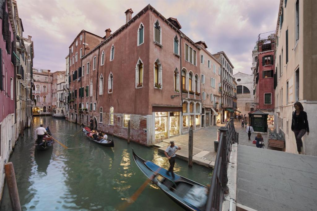 威尼斯的住宿－卡迪坎普酒店，一群人坐在运河里,有建筑物