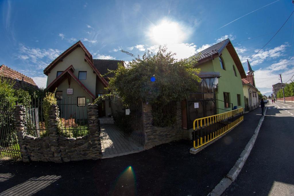 a house with a fence in front of a street at Pensiunea Dragonul in Avrig