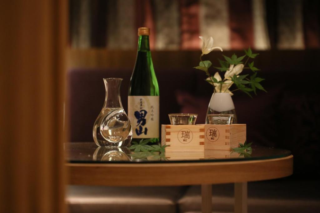 Una mesa con una botella de vino y dos copas. en HOTEL Miz, en Rifu