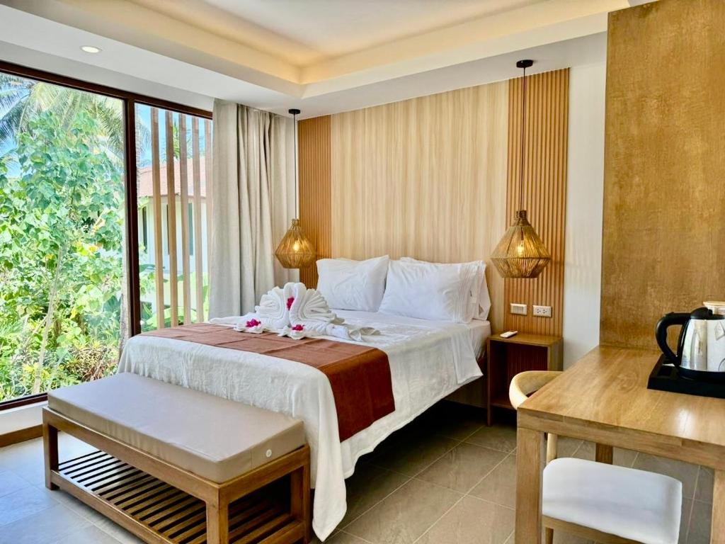 Siargao Island Villas في جنرال لونا: غرفة نوم بسرير ونافذة كبيرة