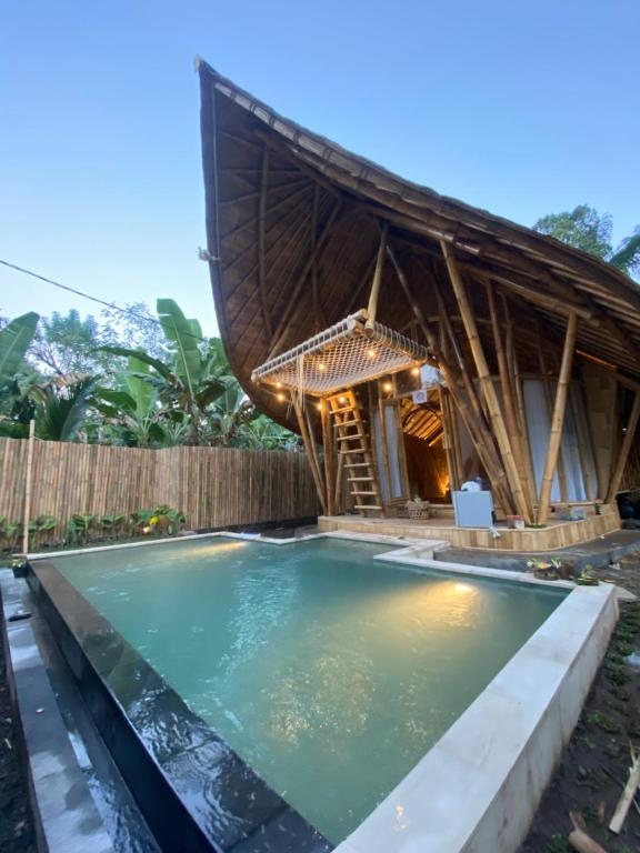 basen przed domem z chatą w obiekcie Bamboo House - Ecobreeze w mieście Sidemen