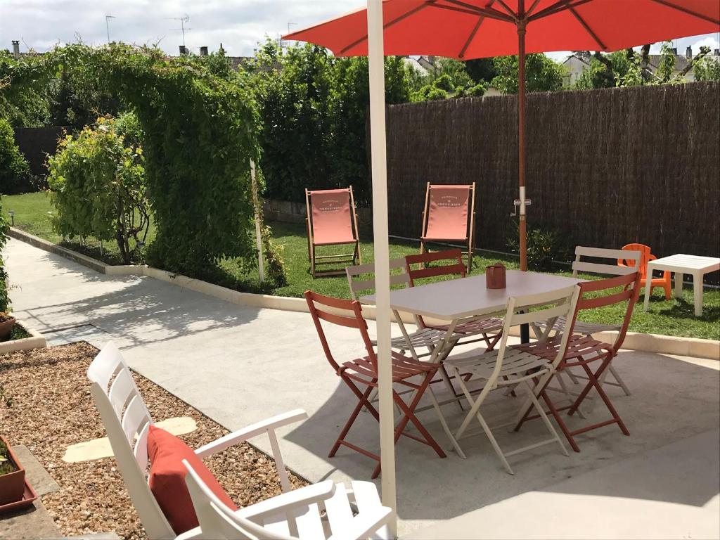 a table and chairs with an umbrella on a patio at Maison rénovée avec jardin, proche du centre, pour 6 pers, Châteauroux - FR-1-591-578 in Châteauroux