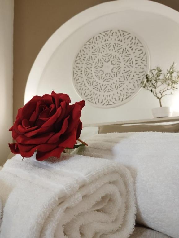 a red rose sitting on top of a pile of towels at Dimora delle rose in Lecce