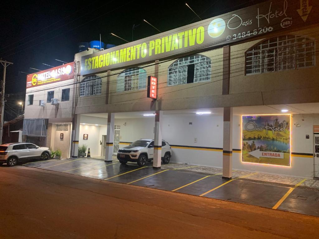 un estacionamiento frente a un edificio por la noche en Hotel Oásis en Brasilia