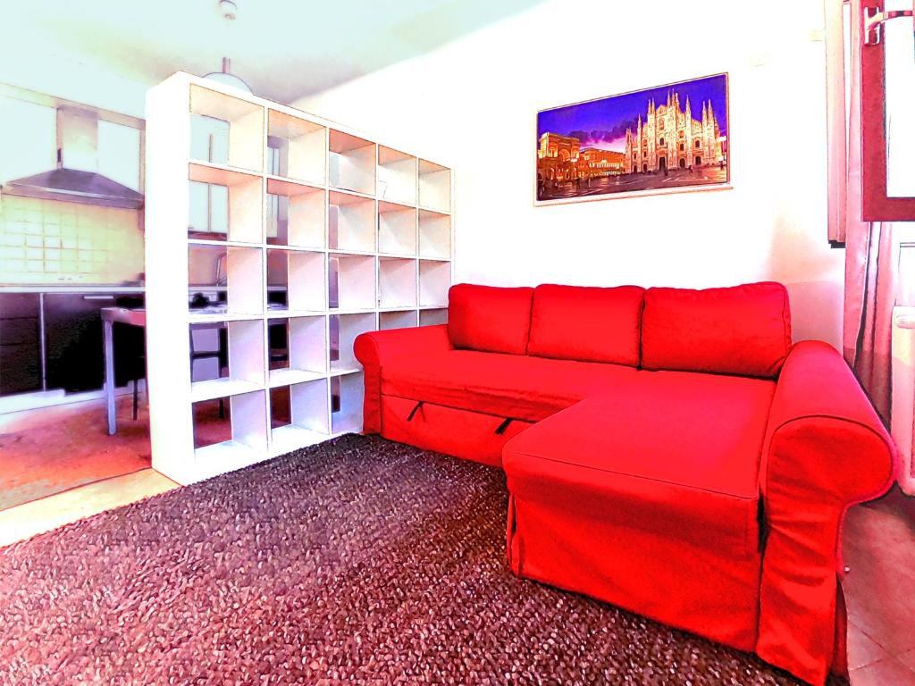 a red couch in a living room with a table at L' appartamento sul Naviglio in Milan