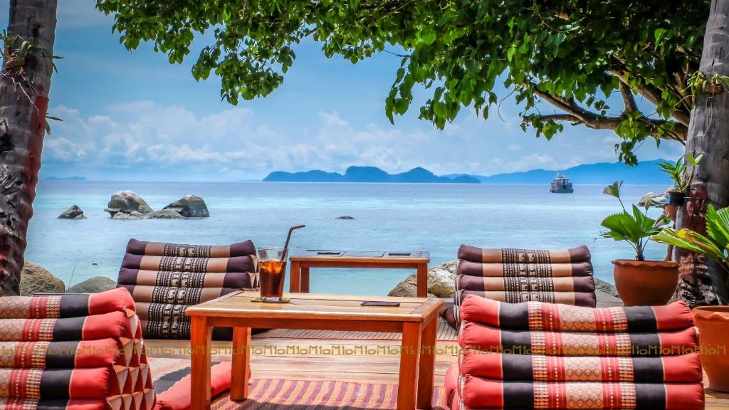 a table and chairs with a view of the ocean at Ten Moons Lipe Resort in Ko Lipe