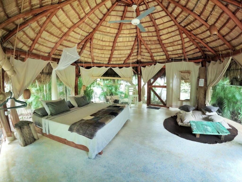 Dream Glamping Jungle Bohio في لاس تاريناس: غرفة نوم بسرير كبير في خيمة