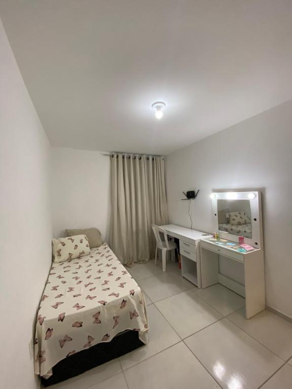 Schlafzimmer mit einem Bett, einem Schreibtisch und einem Spiegel in der Unterkunft Apartamento para São João in Campina Grande