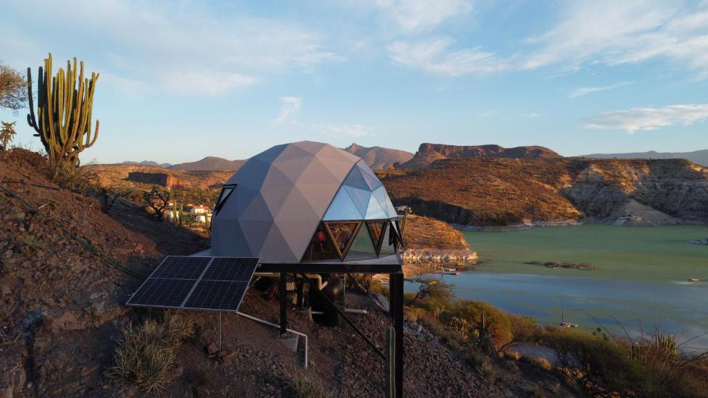 a building on a hill with a view of a river at HOOGA glamping - Presa de Zimapán in Tecozautla