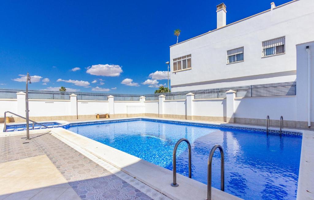 a swimming pool in front of a building at Cozy Home In San Pedro Del Pinatar in San Pedro del Pinatar