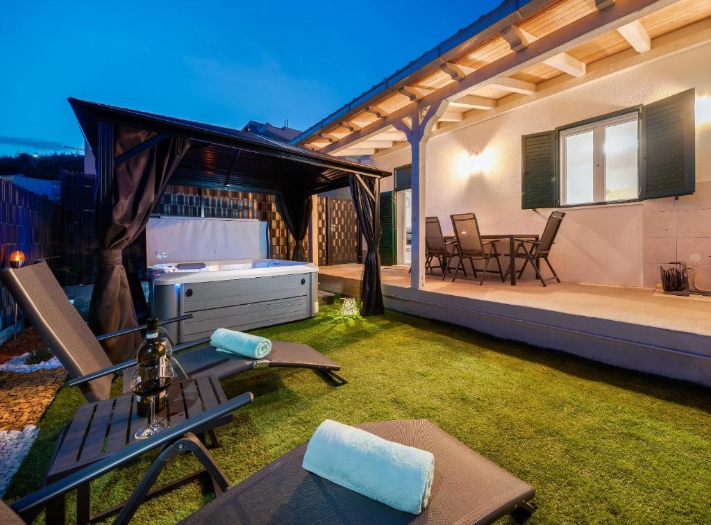 a backyard with a patio with a table and chairs at Holiday house with a parking space Dugi Rat, Omis - 23046 in Dugi Rat