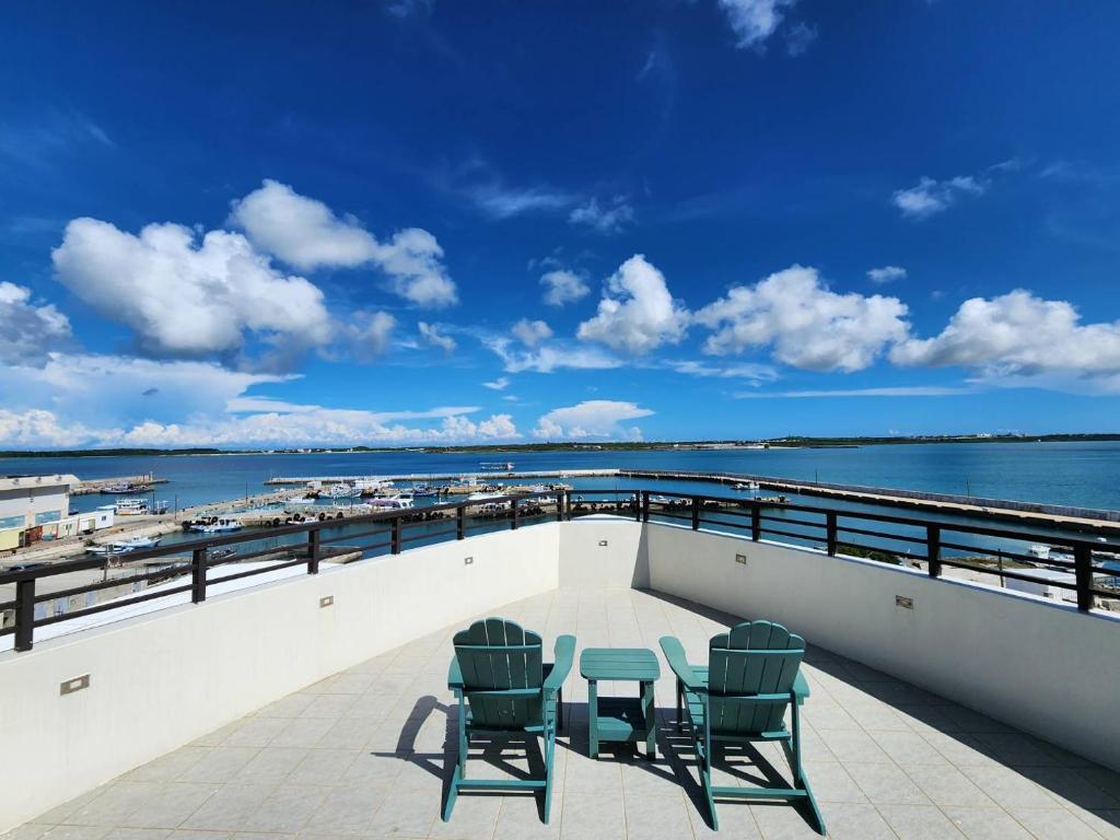 Un balcón con sillas y vistas al océano. en Captain Ou Homestay, en Huxi