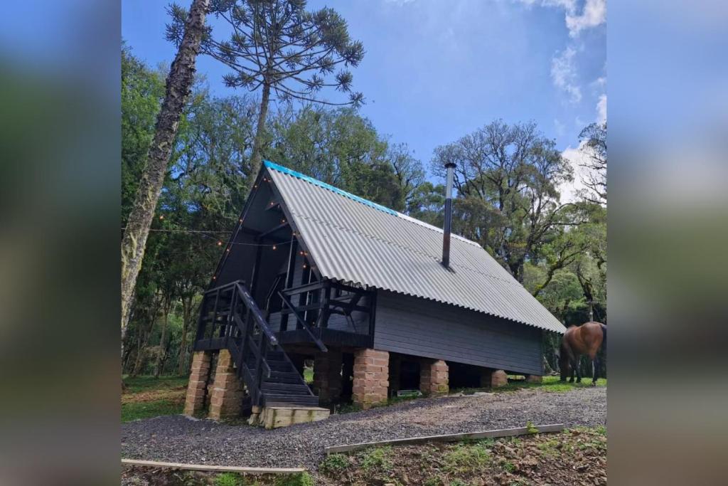 un grande fienile nero con tetto di metallo di Recanto das Folhas - Oásis Pousada a Cambará