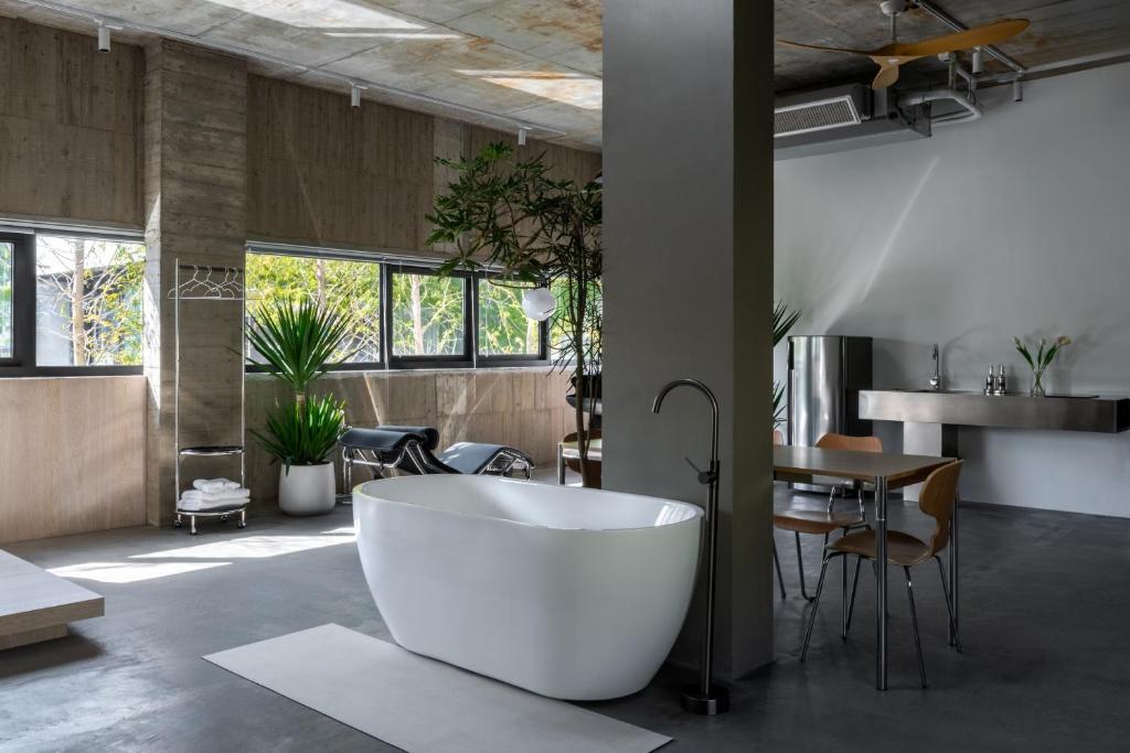 a large white bath tub in a room with a table at Good Stand in Suao