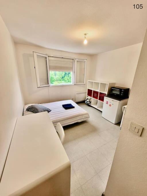 Cette petite chambre comprend un lit et une cuisine. dans l'établissement Studio Centré, Calme & Tout Equipé avec Parking Privé, à Grenoble