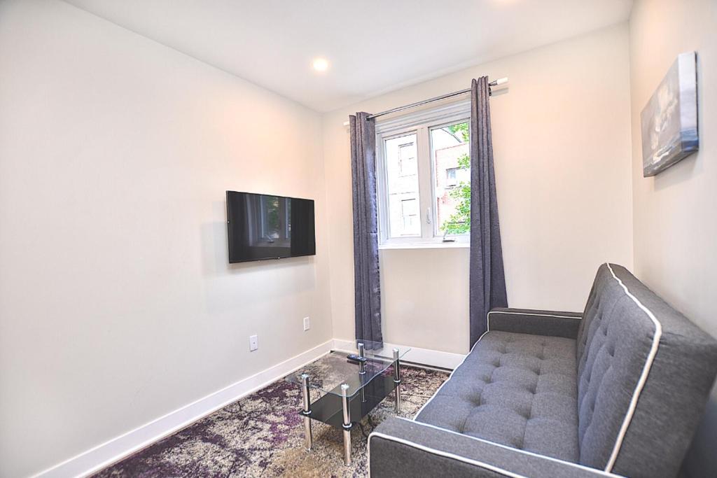 a living room with a couch and a window at Beautiful 2BDR in Heart of Plateau Mont-Royal A in Montréal
