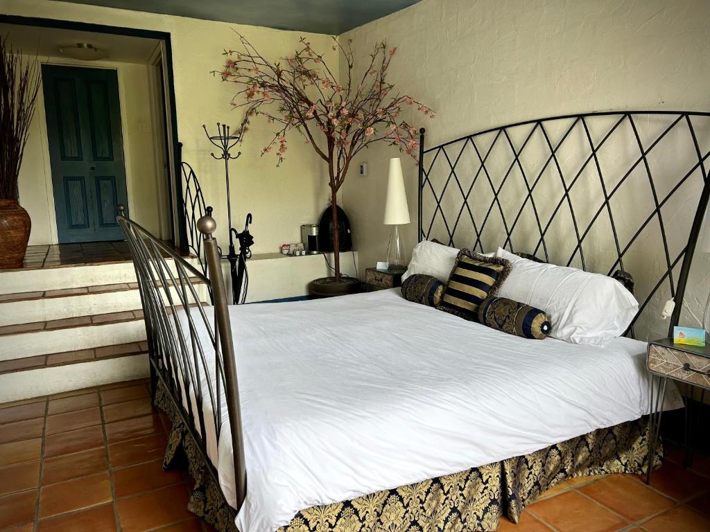 1 dormitorio con 1 cama grande con sábanas blancas en Le Mange Grenouille, en Le Bic