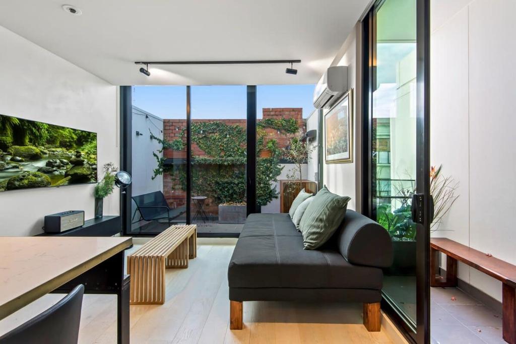 - un salon avec un canapé et une table dans l'établissement MadeComfy Inner City Designer 2-Bed Apartment, à Melbourne