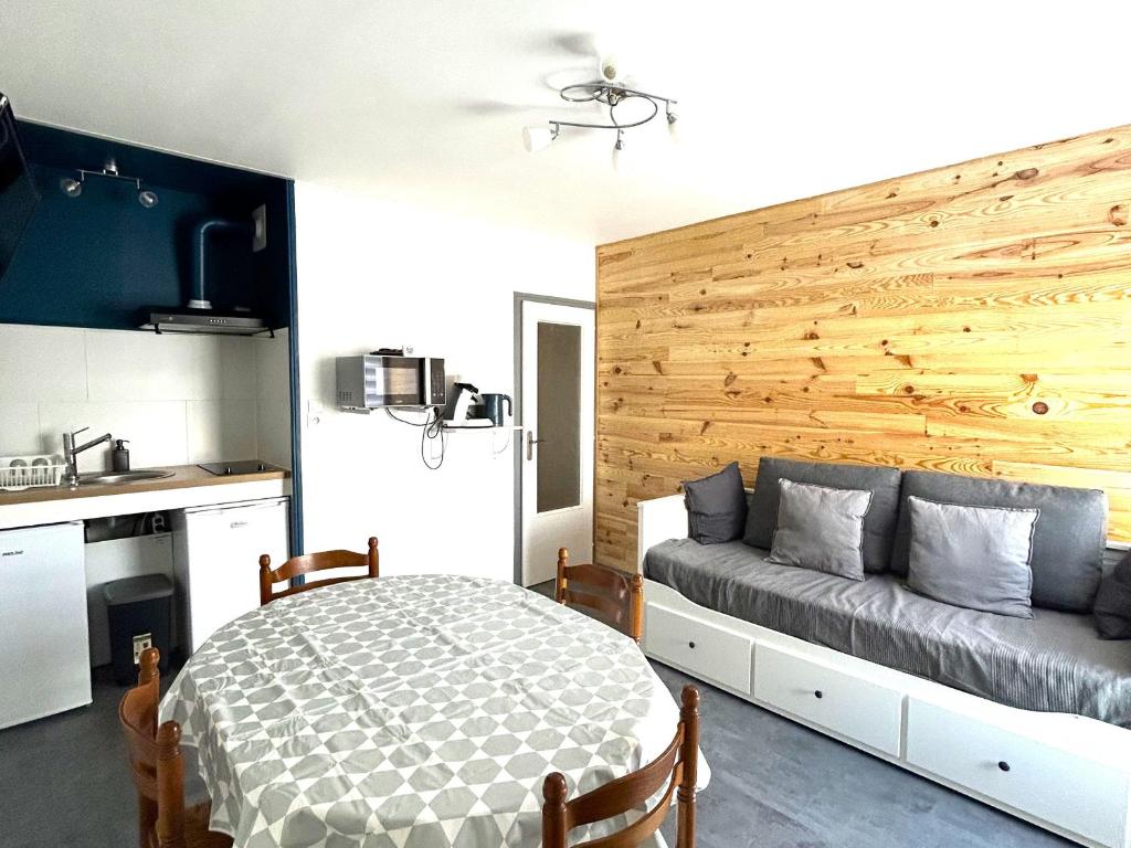 une chambre avec un lit et un mur en bois dans l'établissement Appartement en Front de Mer avec Parking Privatif à St Jean de Monts - Accès Direct Plage & Pistes Cyclables - FR-1-652-42, à Saint-Jean-de-Monts