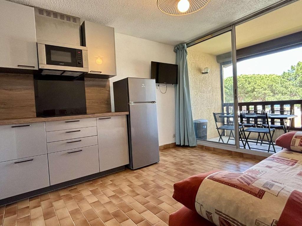 Il comprend une cuisine équipée d'un réfrigérateur et un balcon avec une table. dans l'établissement Studio cabine avec piscine, parking privé et loggia – 4 couchages, proche mer et commerces - FR-1-225-818, à Argelès-sur-Mer