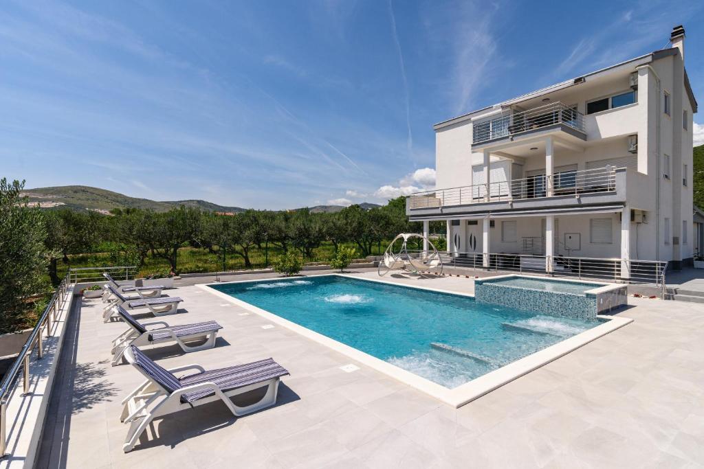 a villa with a swimming pool and a house at Family harmony in Plano