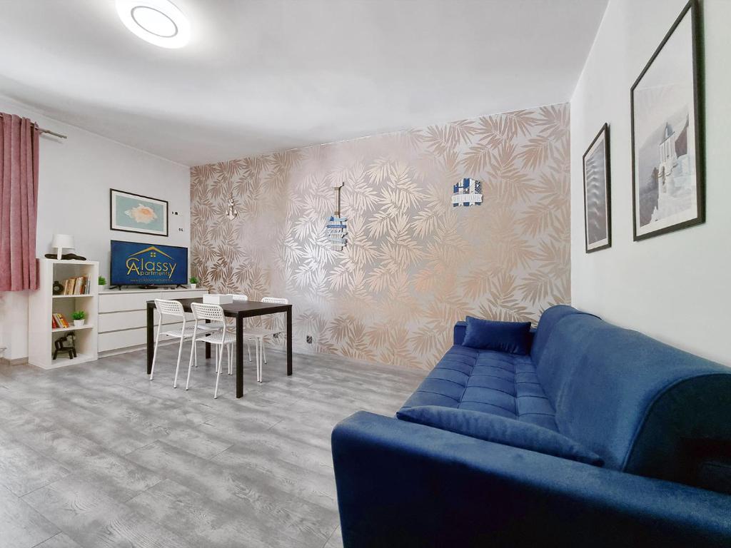 a living room with a blue couch and a table at CLASSY APARTMENTS - Gdynia - Experyment in Gdynia
