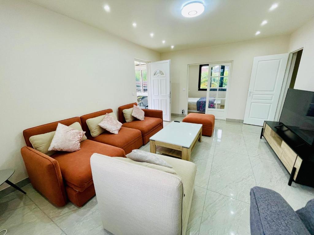 una sala de estar con un sofá y una mesa en Stylish, Calm and Green Home Stay, en Saint-Fargeau-Ponthierry