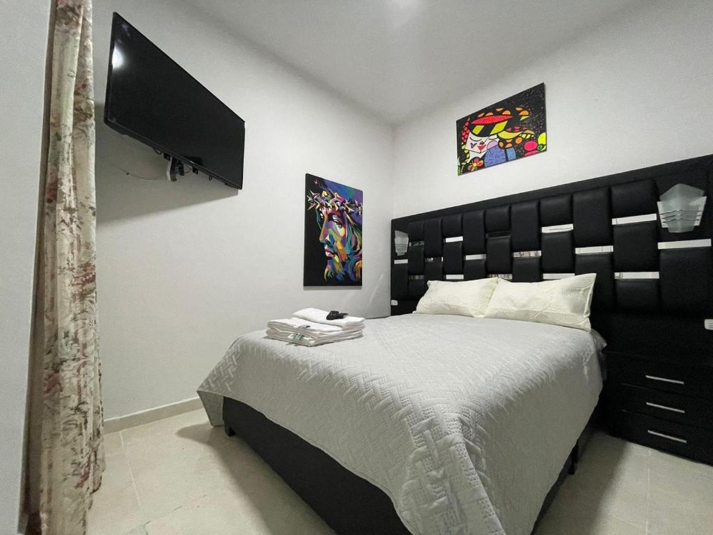 a bedroom with a large bed and a flat screen tv at VIVENTO Habitaciones Lujosas Estrato 6 Frente Campanario in Popayan