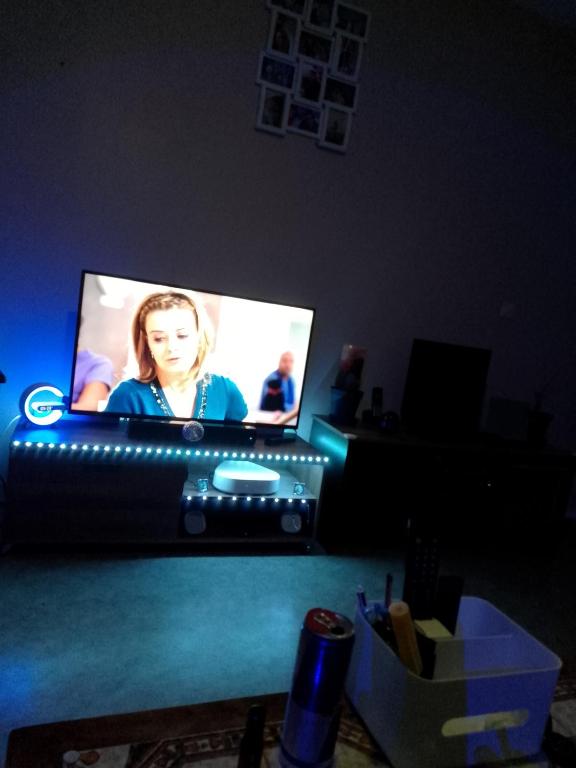 un écran de télévision dans une pièce sombre avec une personne dans l'établissement dimtitine, à Villeneuve d'Ascq