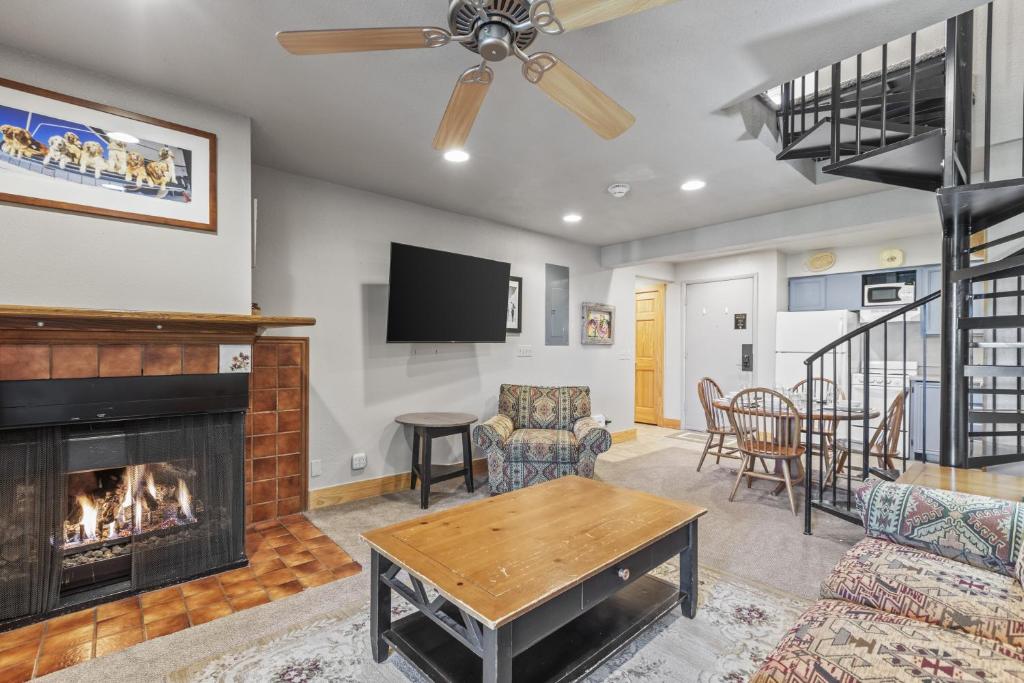 ein Wohnzimmer mit Kamin und Fernseher in der Unterkunft SNOW FLOWER 072 condo in Park City