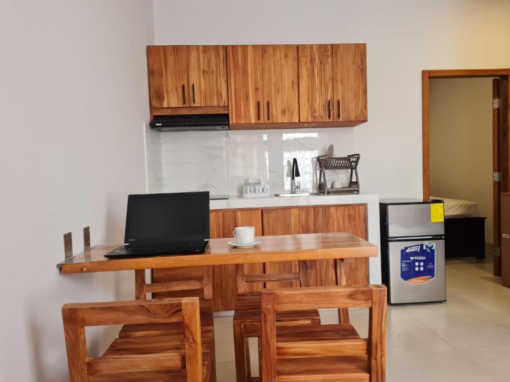 eine Küche mit einem Tisch und einem Laptop darauf in der Unterkunft Rivera Suites El Girasol - Puerto López in Puerto López