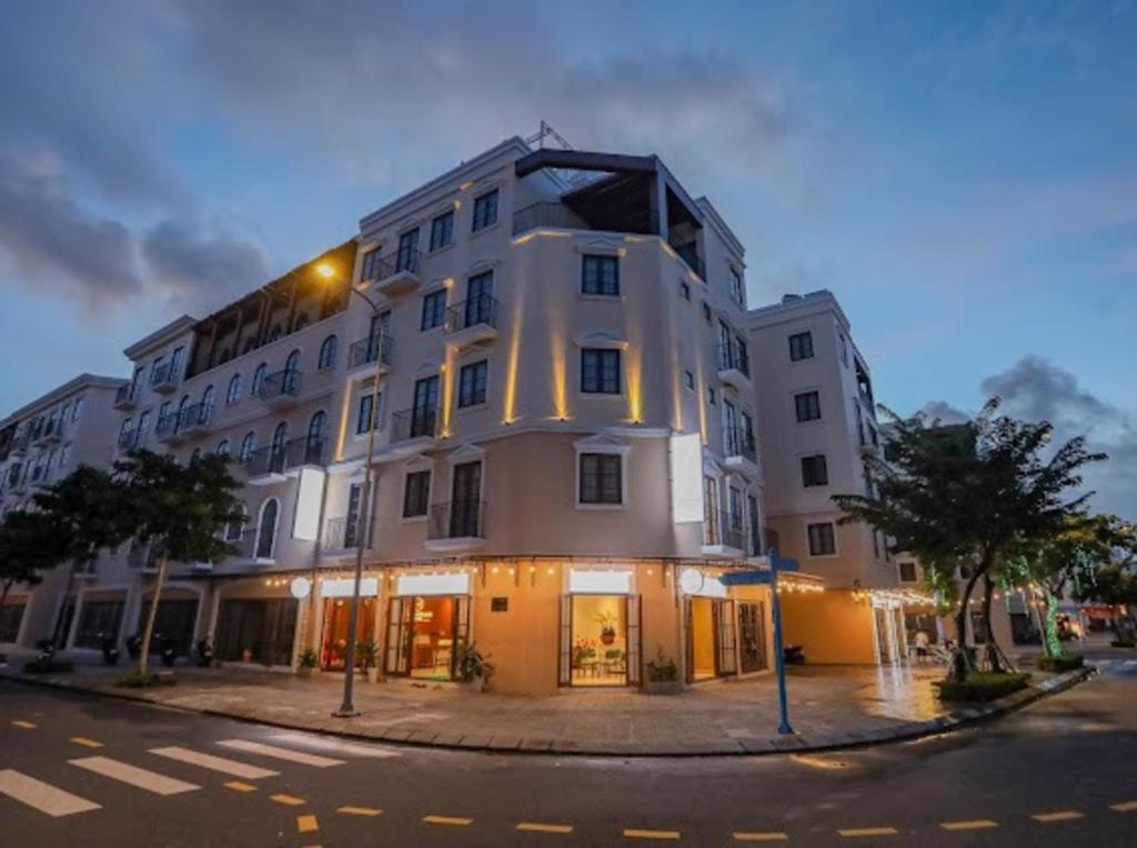 a large white building on the corner of a street at Mimosa Hotel Phú Quốc in Phu Quoc