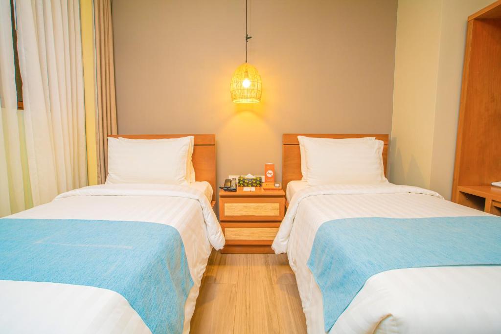 1 Schlafzimmer mit 2 Betten und einer Leuchte in der Unterkunft Charlie's El Nido Managed by HII in El Nido