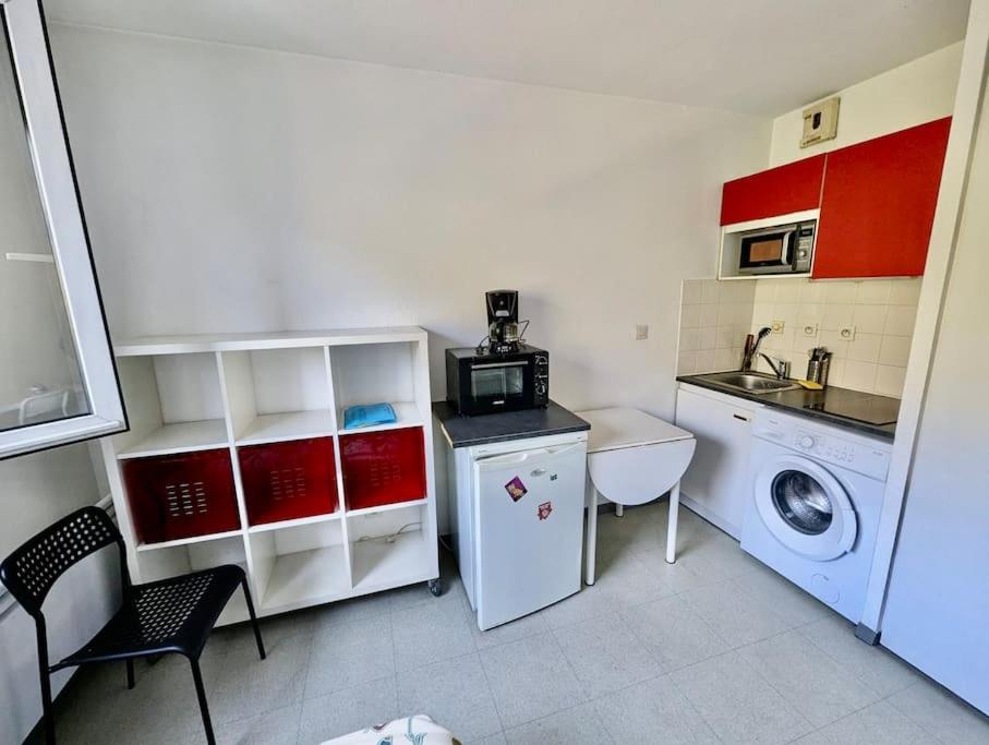a small kitchen with a washing machine and a washer at Studio 105 - Calme & Tout Equipé avec Parking Gratuit in Grenoble