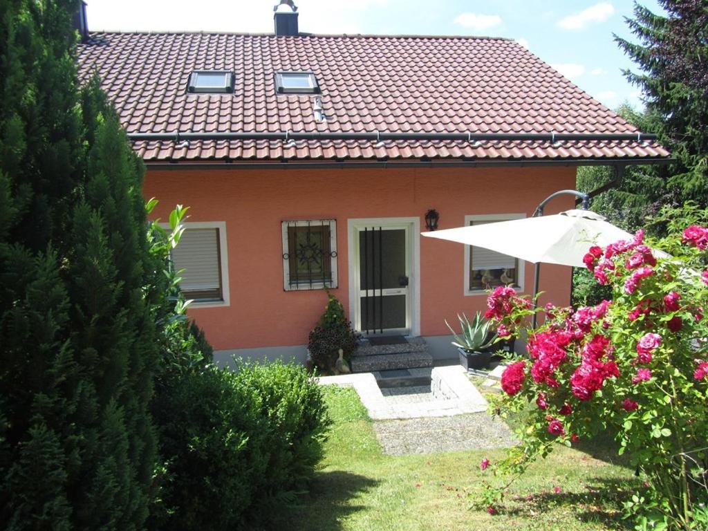 ein Haus mit einem Regenschirm und ein paar Blumen in der Unterkunft Ferienhaus Fanny in Lam