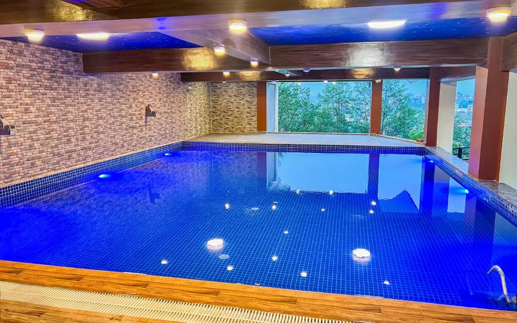 una grande piscina in un edificio con una grande finestra di Sky Garden Resort a Dhulikhel