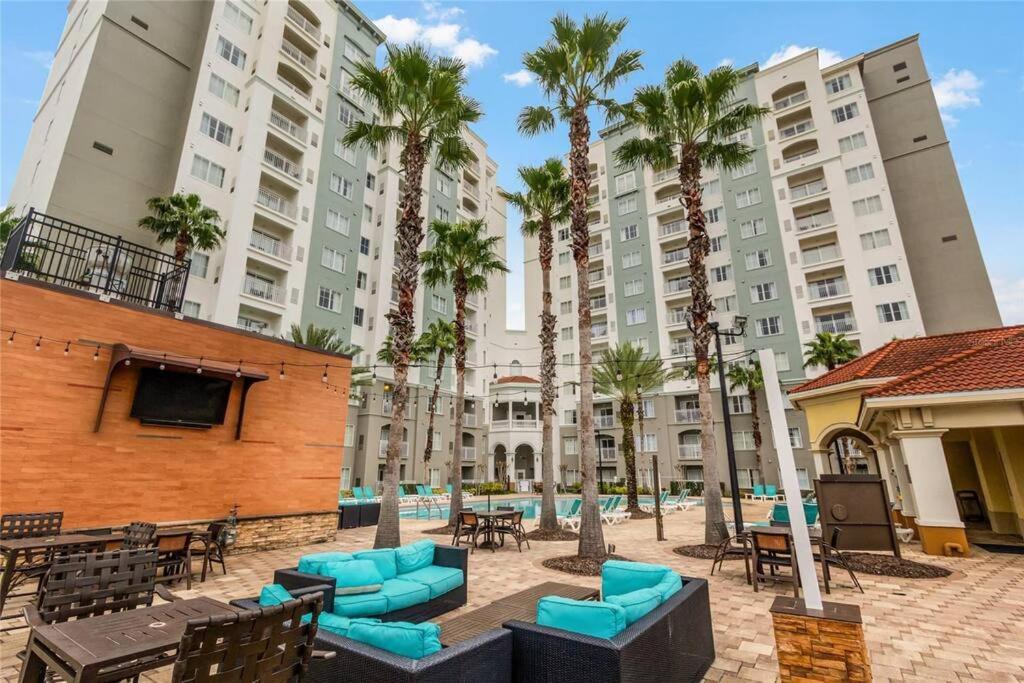 a courtyard with chairs and palm trees and buildings at Premier Resort Condos Near Disney & Universal in Orlando