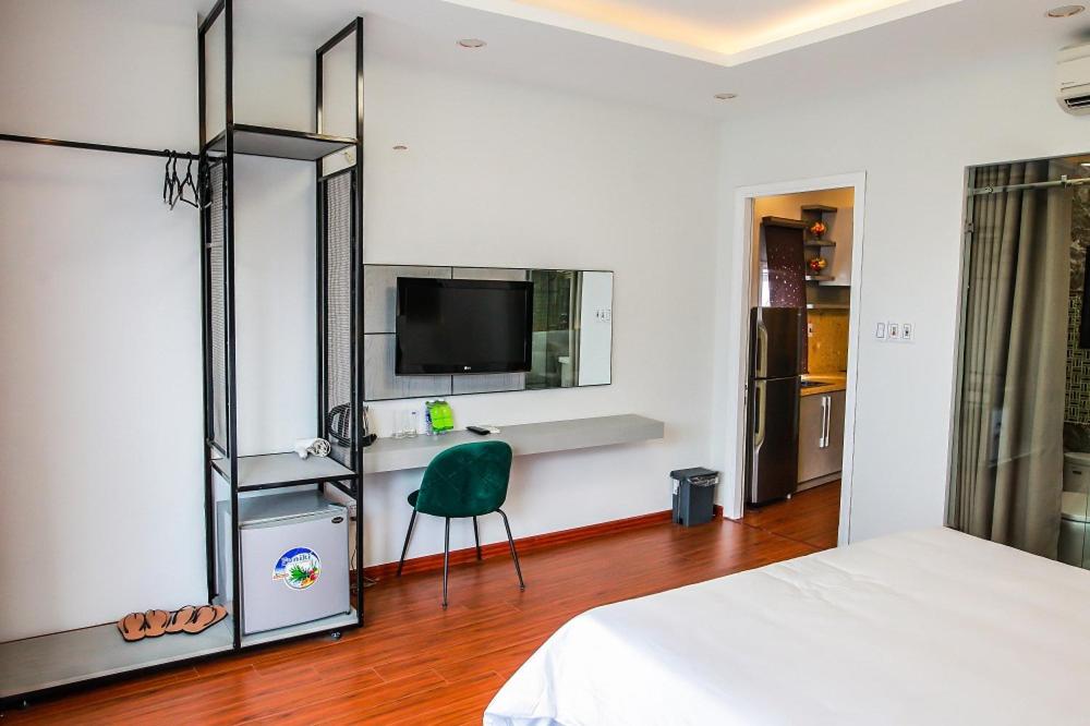 a bedroom with a bed and a tv and a chair at Mayana Hotel DN - by BAY LUXURY in Da Nang