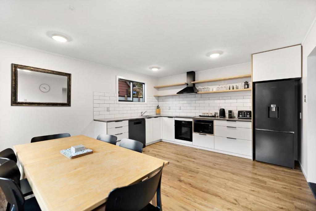 a kitchen and dining room with a table and refrigerator at Town centre house. Perfect for families and groups in Queenstown