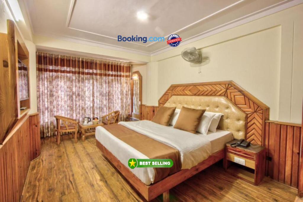 um quarto com uma cama grande num quarto em Goroomgo i Bex Manali Near Mall Road- Best Choice of Travellers em Manali