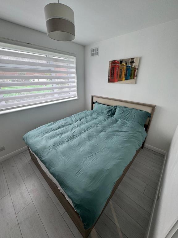 - une chambre avec un lit et une couette verte dans l'établissement Carmen’s Flat, à Londres
