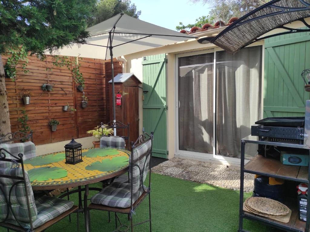 a patio with a table and chairs with an umbrella at Maison la ciotat in La Ciotat