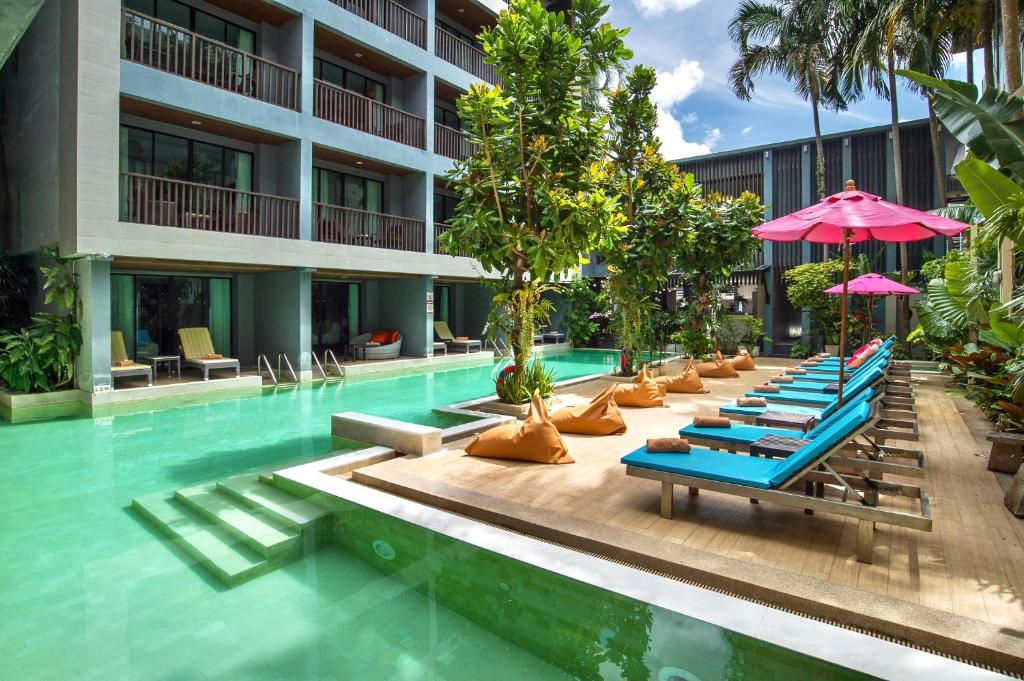 una piscina con sedie a sdraio e ombrelloni di Aree Tara Ao Nang Krabi ad Aonang Beach