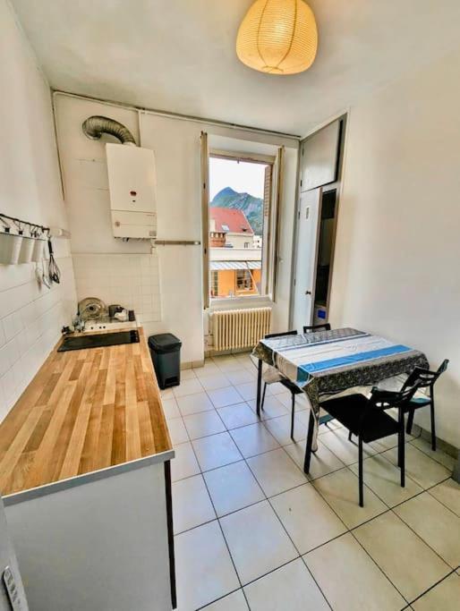 une cuisine avec une table et des chaises dans une pièce dans l'établissement T2 Berriat - Proche Gare & Centre - Tout Equipé avec Wifi, à Grenoble