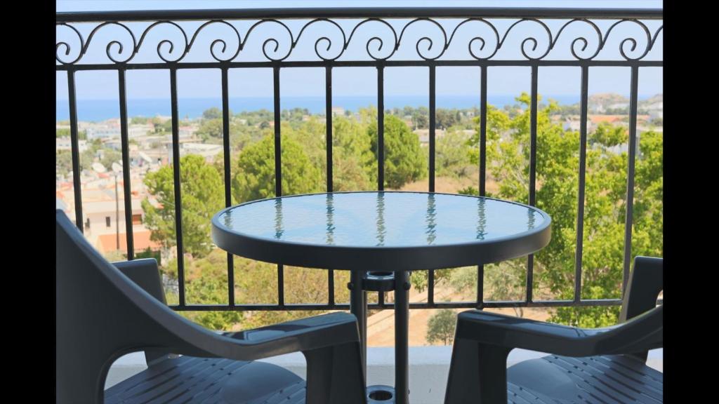 een tafel en stoelen op een balkon met uitzicht bij Planet View in Faliraki