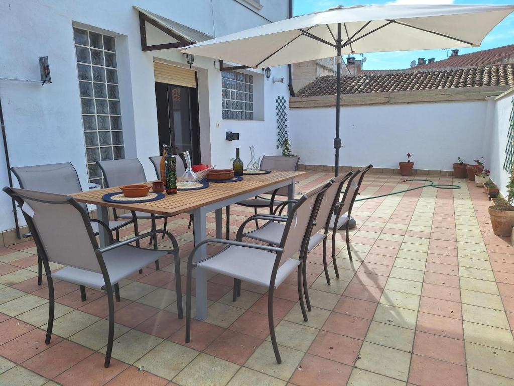 einen Holztisch mit Stühlen und einem Sonnenschirm auf einer Terrasse in der Unterkunft La casa del aguador, BTT y Senda Viva in Alfaro