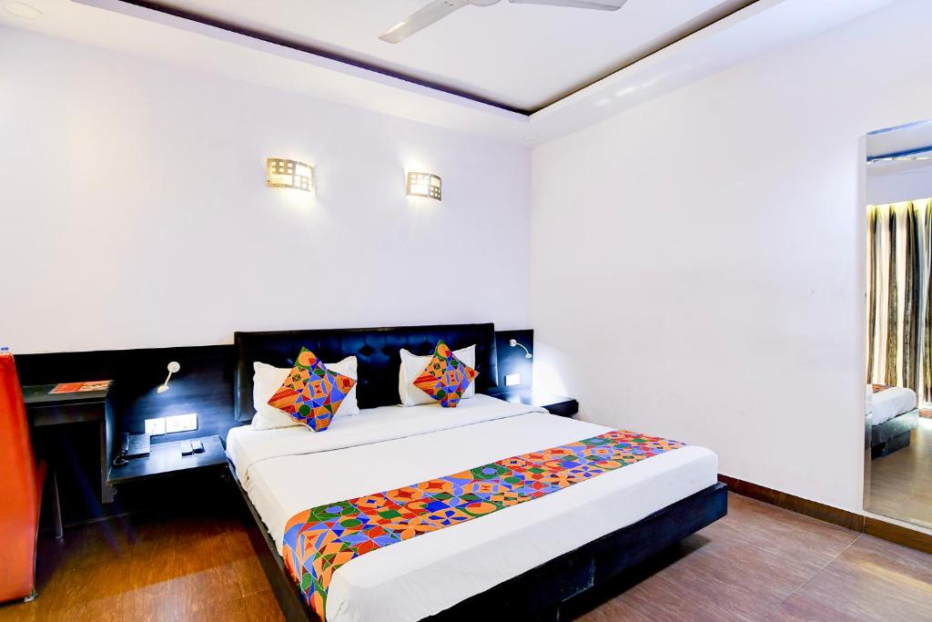 een slaapkamer met een groot bed met kleurrijke kussens bij FabHotel 1 Lovelock in Ballygunge