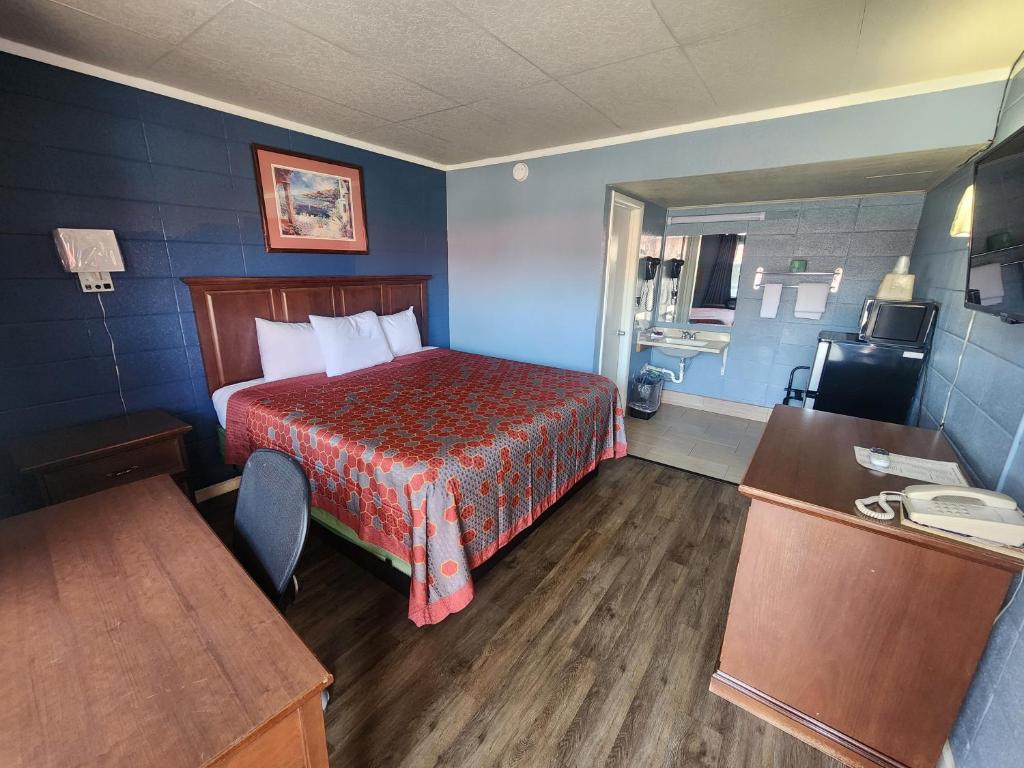 Habitación de hotel con cama con manta roja en Guest House Motel en Carthage
