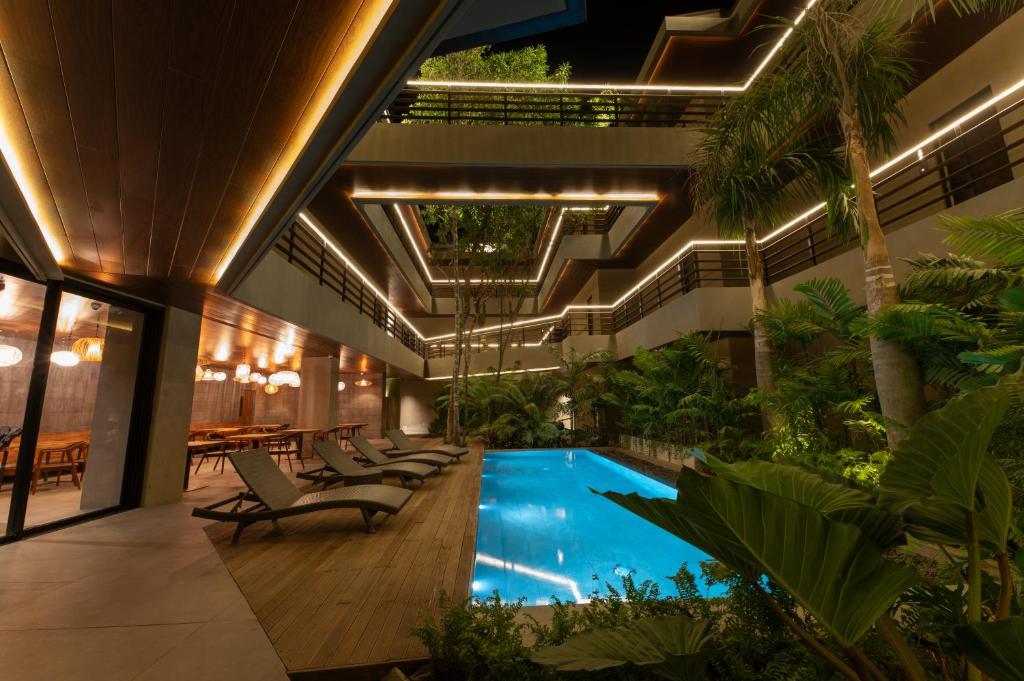 uma piscina interior num edifício com cadeiras e plantas em Piece Lio Resort from Japan em El Nido